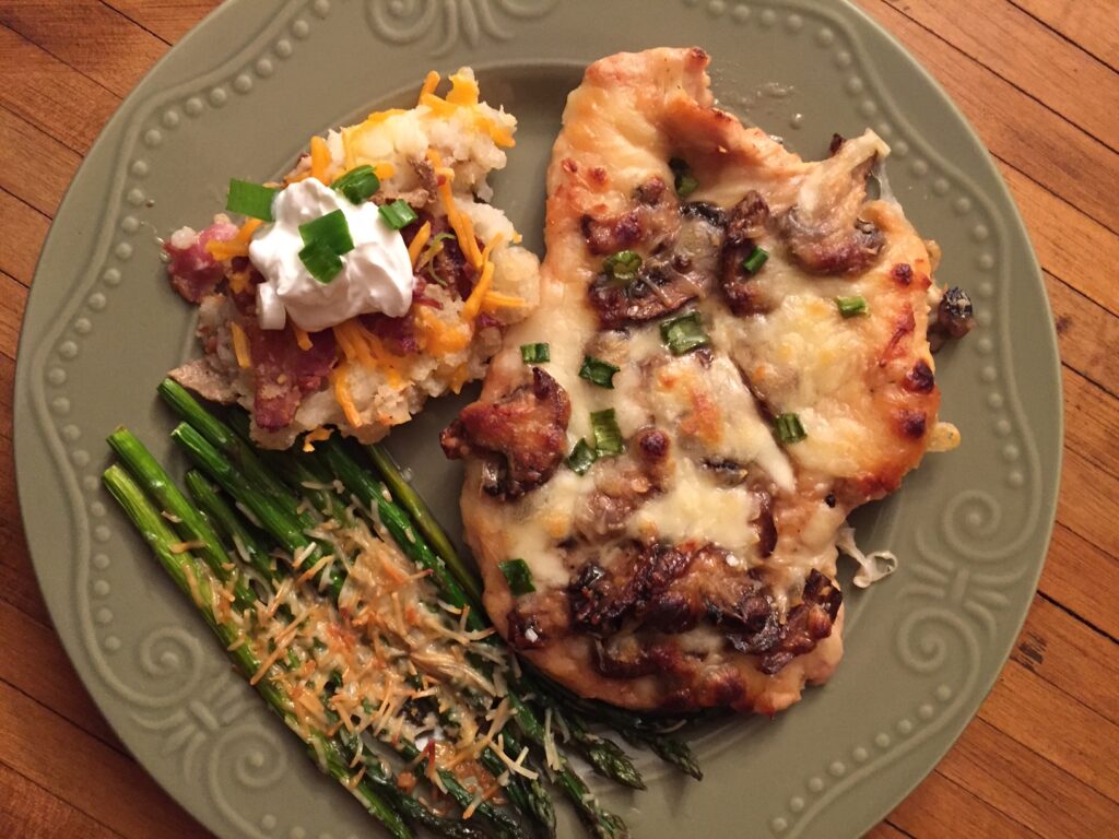 chicken lombardy served with twice baked potato casserole and parmesan garlic asparagus