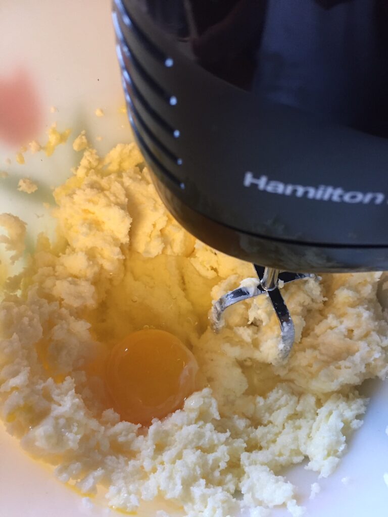 adding an egg to the cake batter