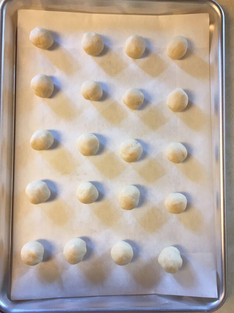 cookie dough balls on a parchment lined cookie sheet