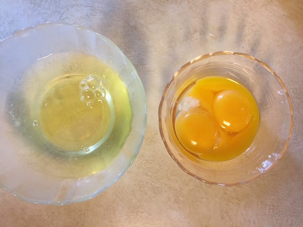 a bowl of egg whites and a bowl of egg yolks