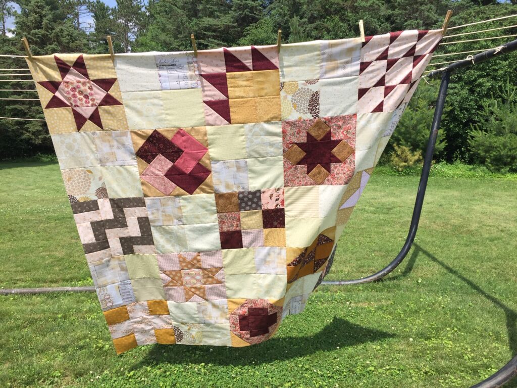 to the nines quilt top flimsy hanging on the line to display
