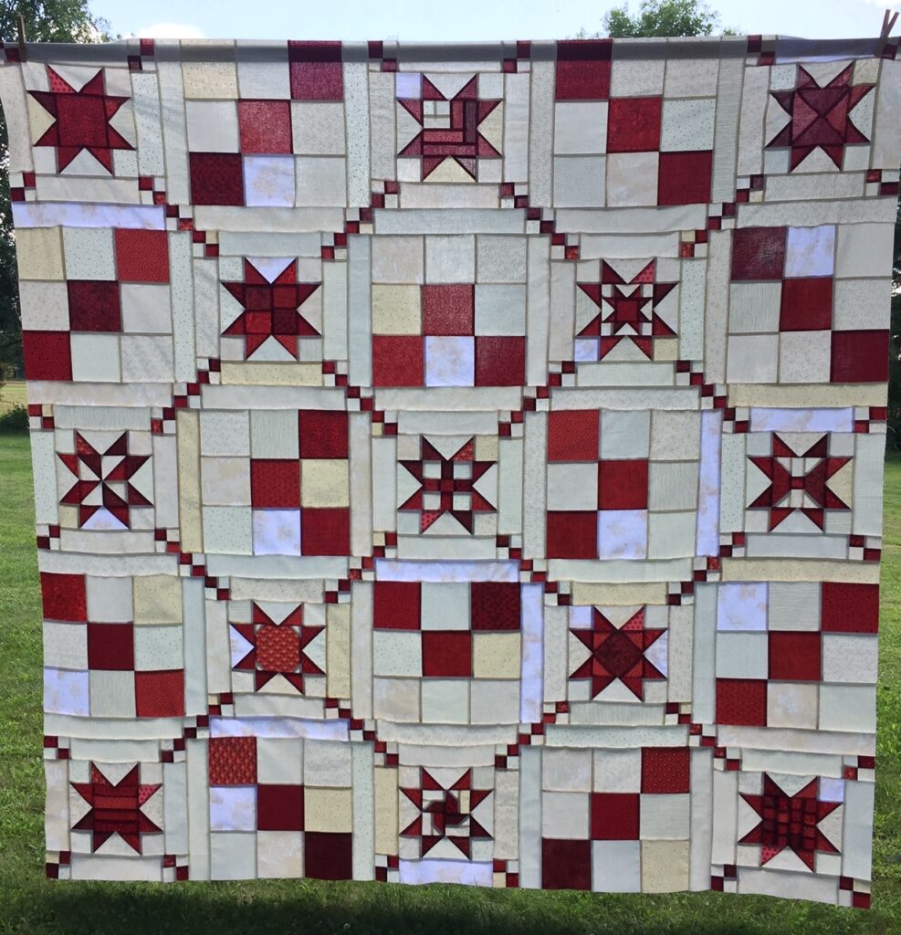 scrappy stars quilt top hanging outside