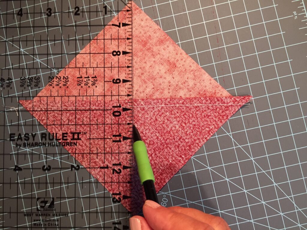 drawing diagonal line on a half square triangle block used to make the easy quarter square triangle blocks