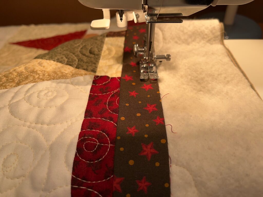 beginning to sew binding strip on quilt