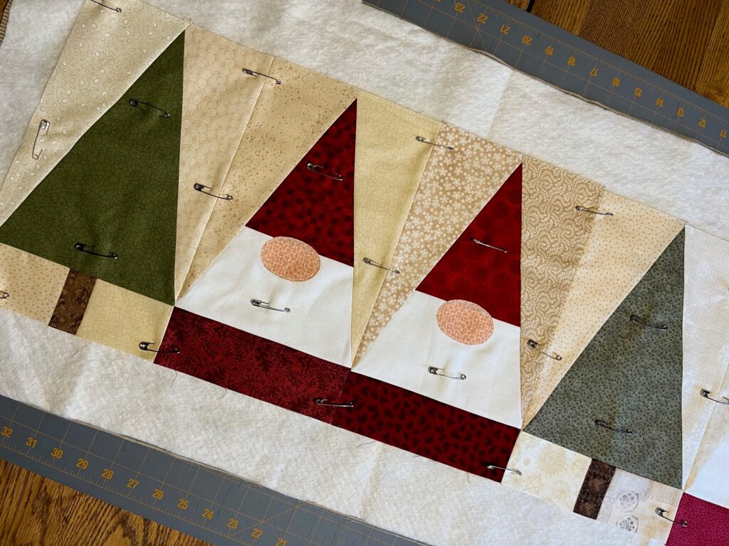 pin basting on balsam gnomes table runner quilt