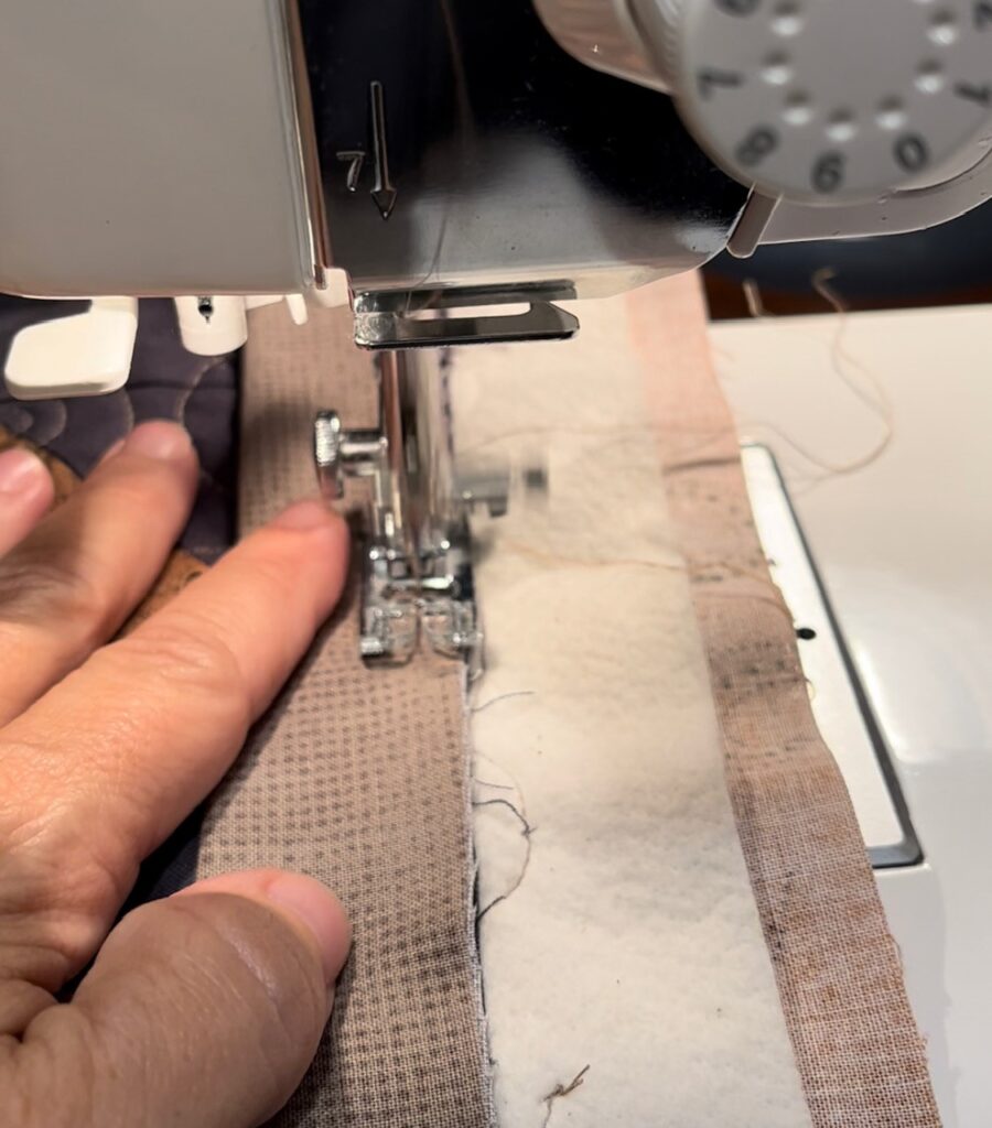 sewing binding strip on quilt 