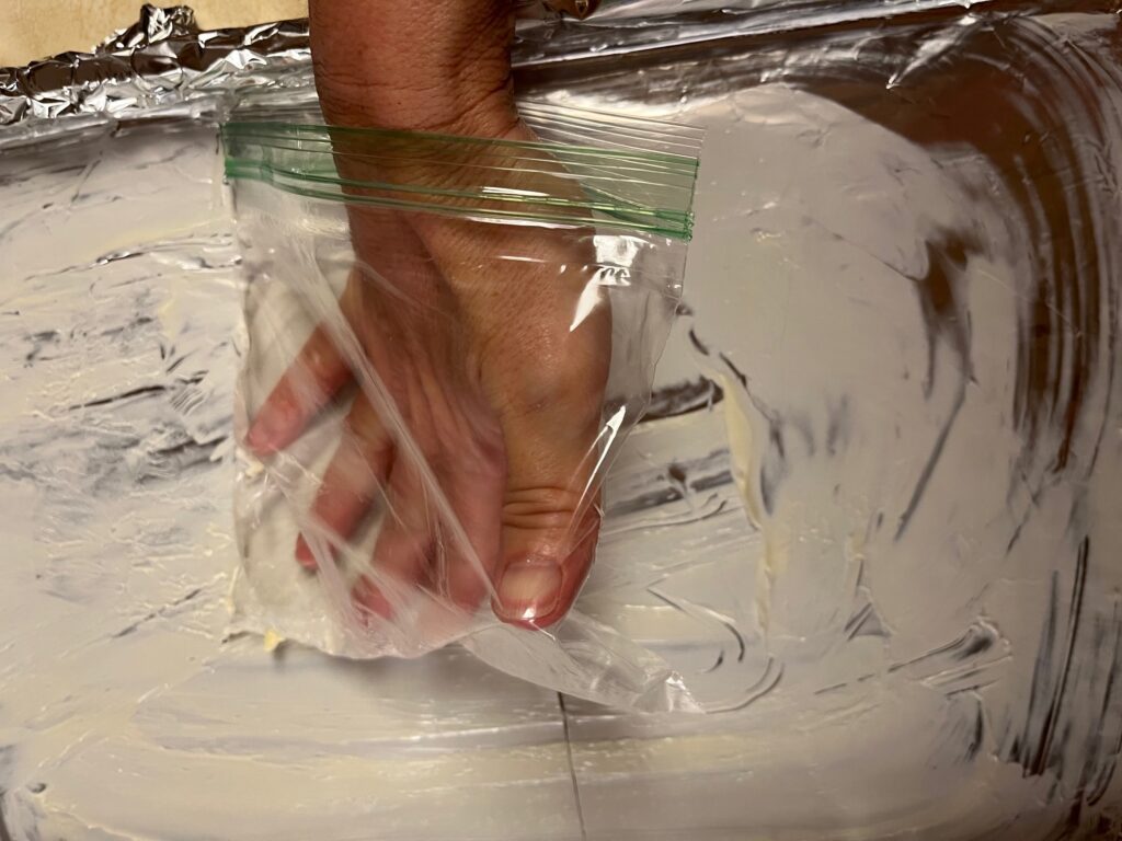 buttering aluminum foil in baking pan for soft homemade caramel recipe